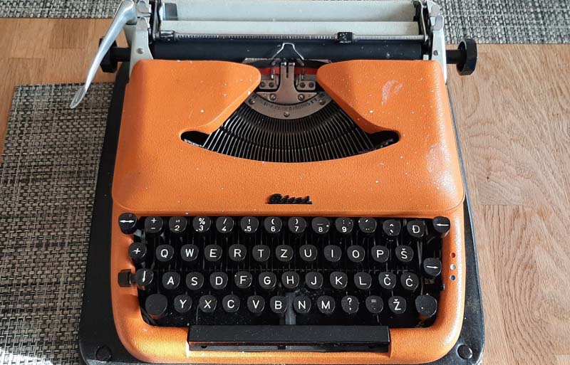Orange Schreibmaschine meines Vaters auf einem Tisch.